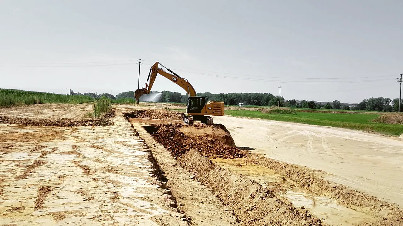 Escavatore Caterpillar in carico su camion sul fronte di una cava di inerti