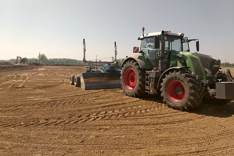 Trattore Fendt 828 Vario con livellatrice a controllo laser durante il livellamento di un terreno agricolo