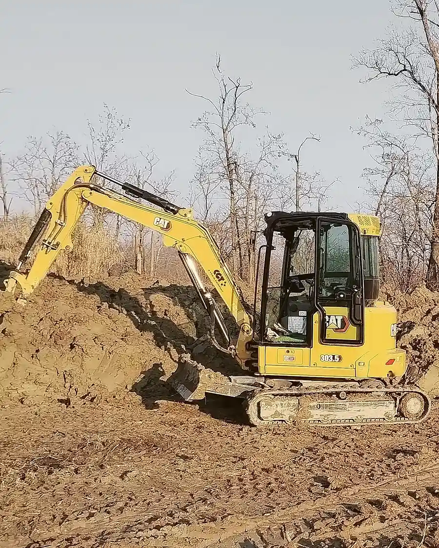 Miniescavatore Caterpillar 303.5 CR Next Generation durante la riprofilatura di una scarpata